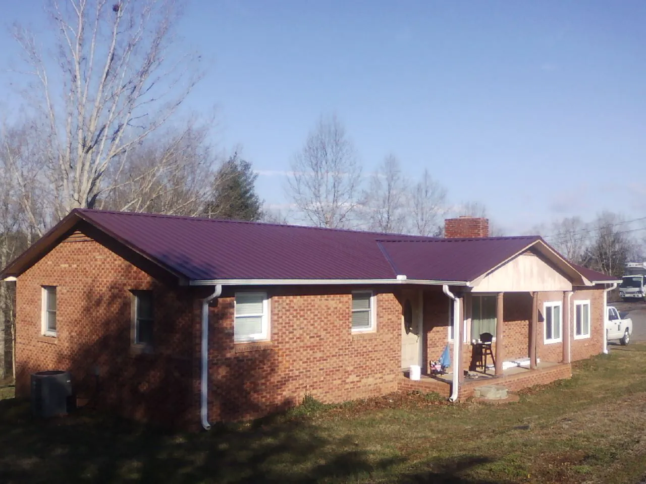 Burgundy metal roof on a brick ranch home with a new addition in Brogue