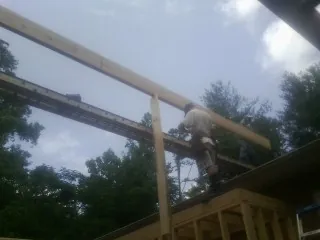Carpenter setting a ridge beam over a new addition frame — Ice Dam Removal by Roofing Brothers in Brogue