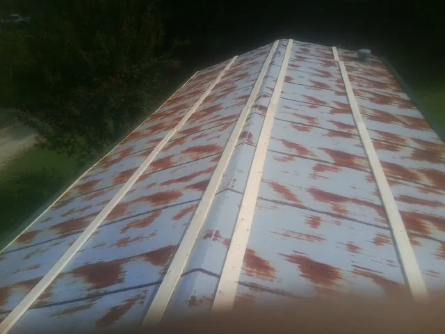 Rusted metal roof panels with new wood purlins before replacement — Storm Damage Roof Repair in Brogue by Roofing Brothers