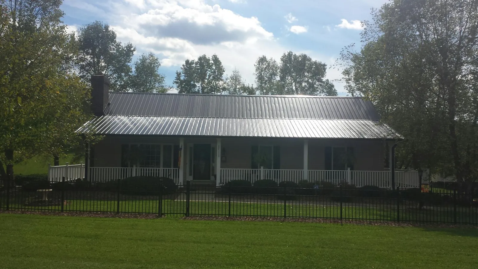 Gray metal roof on a brick ranch with a full width front porch — Gutter Guard Installation work by our crew in Brogue